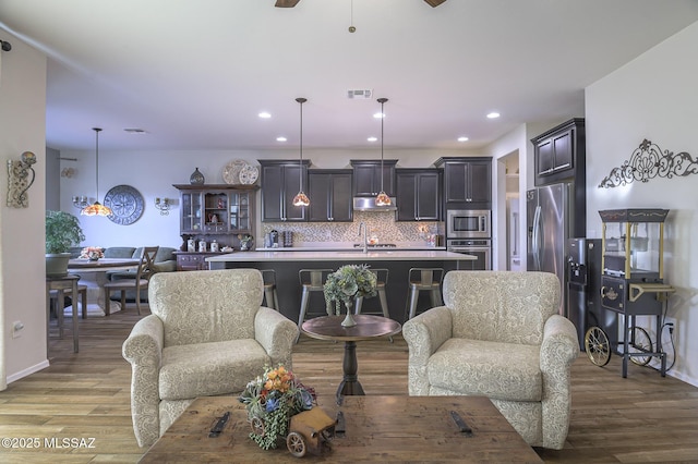 living room with sink and light hardwood / wood-style flooring