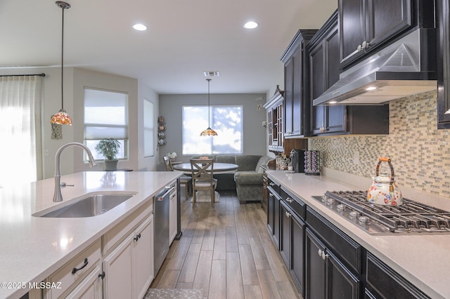 kitchen with hanging light fixtures, sink, decorative backsplash, and stainless steel appliances