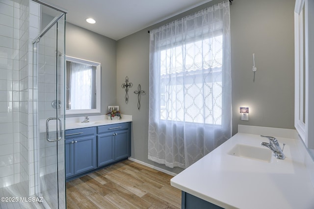 bathroom with walk in shower, vanity, hardwood / wood-style floors, and plenty of natural light