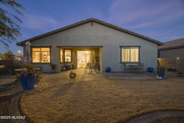 back house at dusk with a patio