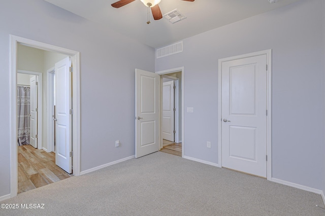 unfurnished bedroom with light carpet, ceiling fan, and ensuite bath