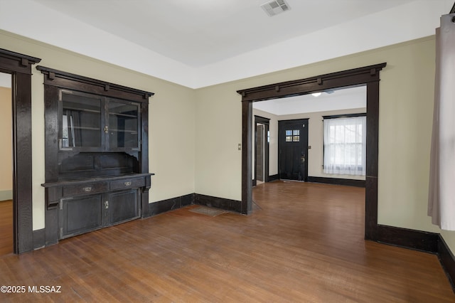 empty room featuring a barn door and dark hardwood / wood-style floors