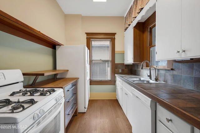 kitchen with sink, white appliances, light hardwood / wood-style floors, white cabinets, and decorative backsplash