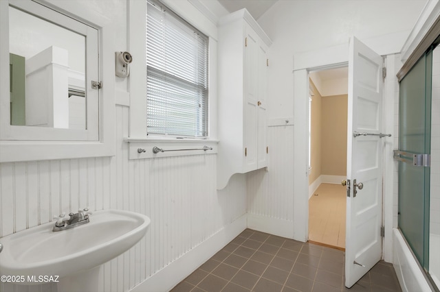 bathroom featuring combined bath / shower with glass door, sink, and tile patterned floors