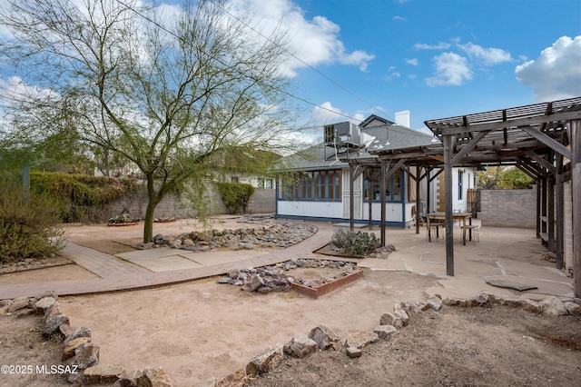 rear view of house featuring central AC unit, a pergola, a sunroom, and a patio