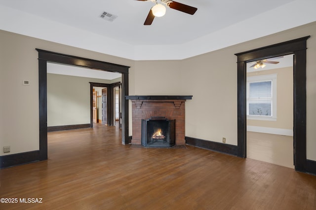 unfurnished living room featuring hardwood / wood-style floors, a fireplace, and ceiling fan