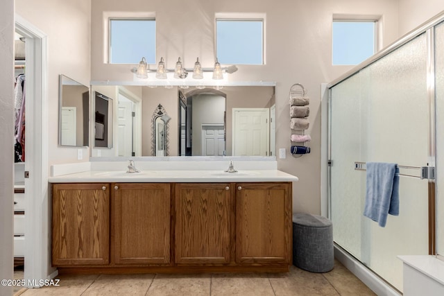 bathroom featuring tile patterned flooring, vanity, plenty of natural light, and a shower with shower door