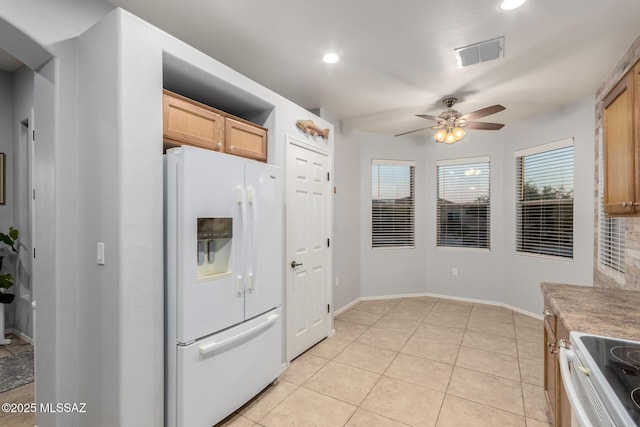 kitchen featuring light tile patterned floors, ceiling fan, range with electric cooktop, white refrigerator with ice dispenser, and light brown cabinets