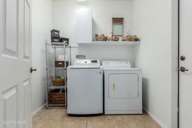 laundry room featuring light tile patterned flooring and separate washer and dryer