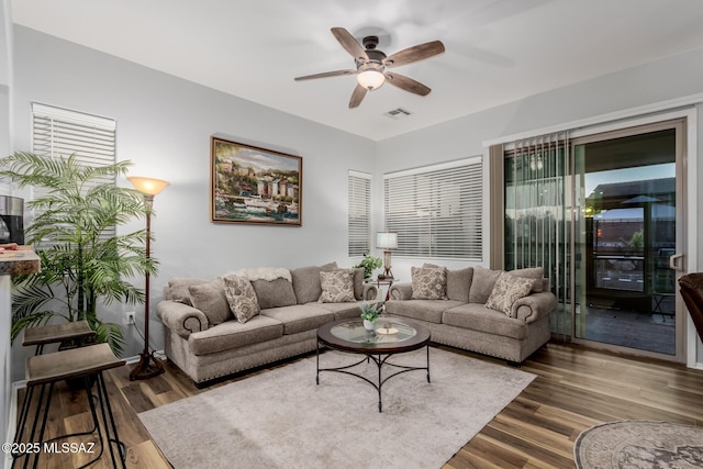 living room featuring ceiling fan and dark hardwood / wood-style flooring