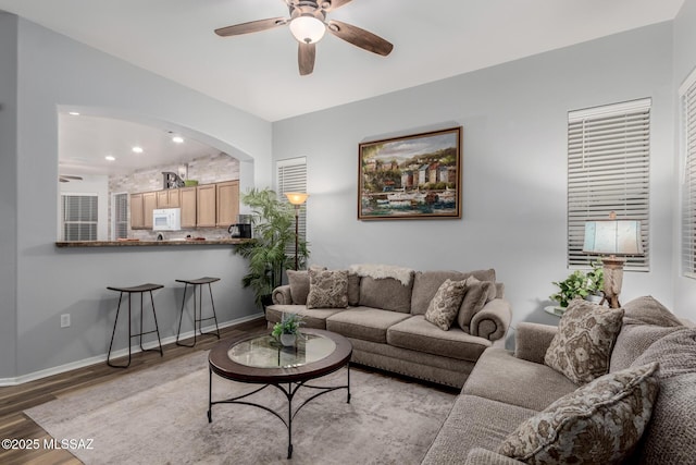 living room with light hardwood / wood-style flooring and ceiling fan