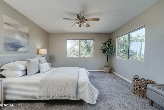 carpeted bedroom with multiple windows and ceiling fan