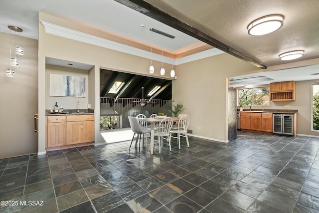 dining space featuring wine cooler, wet bar, and a textured ceiling