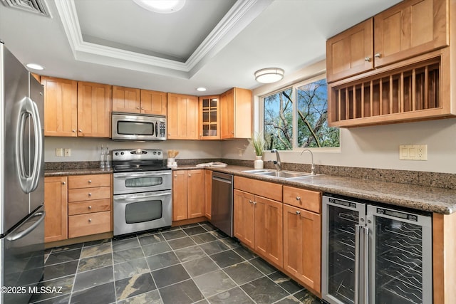 kitchen with sink, appliances with stainless steel finishes, wine cooler, a tray ceiling, and ornamental molding