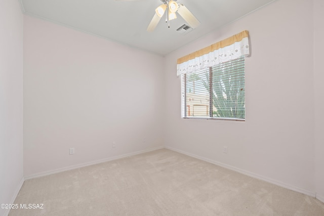 unfurnished room with ceiling fan, visible vents, baseboards, and light colored carpet