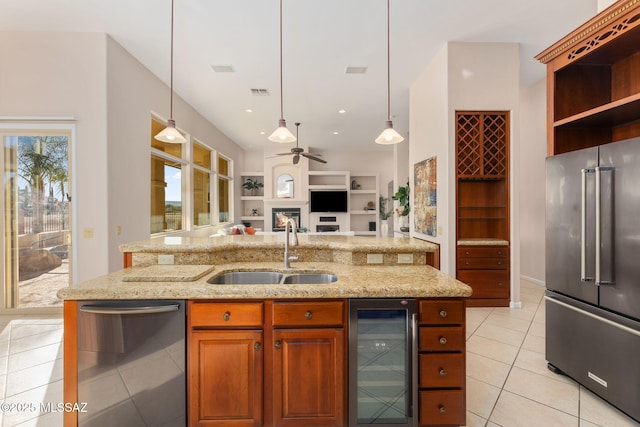 kitchen with beverage cooler, a sink, open floor plan, appliances with stainless steel finishes, and light tile patterned floors