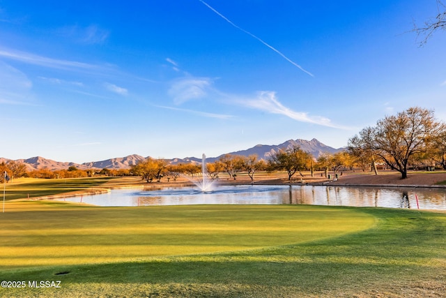 view of property's community with a yard, golf course view, and a water and mountain view