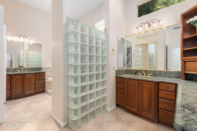 bathroom with a healthy amount of sunlight, walk in shower, and a sink