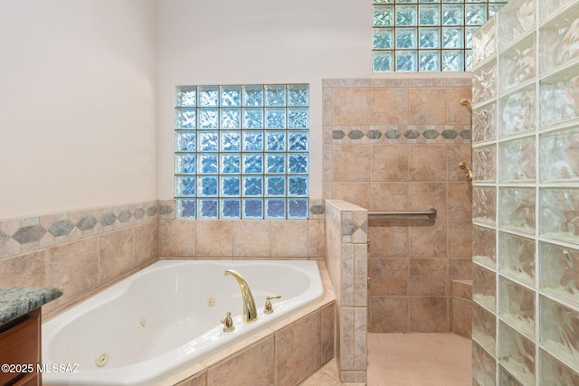 bathroom featuring vanity, walk in shower, and a whirlpool tub