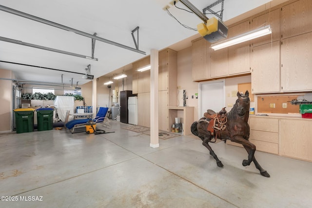 garage with a garage door opener and freestanding refrigerator