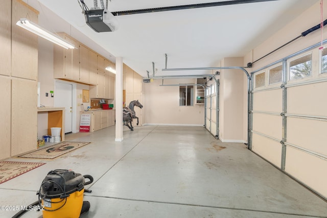 garage with a garage door opener and baseboards