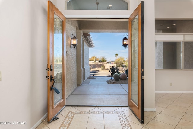 doorway to outside featuring light tile patterned floors and baseboards