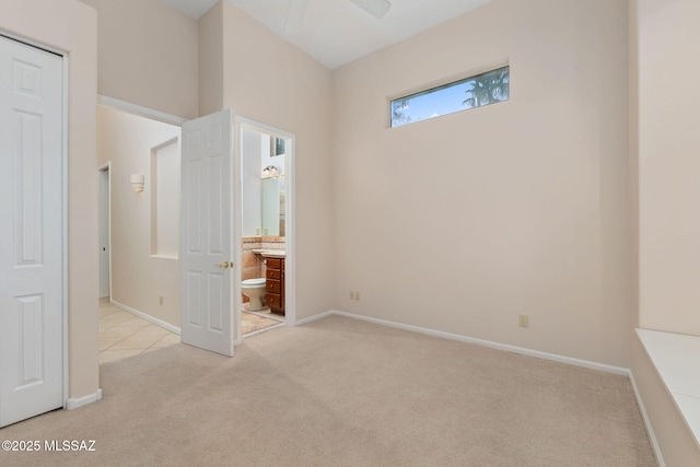 unfurnished bedroom featuring connected bathroom, baseboards, and carpet flooring