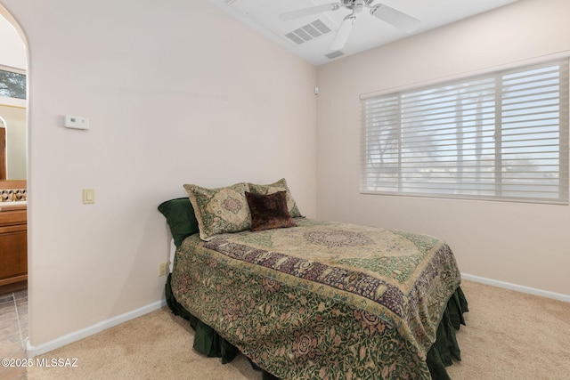 carpeted bedroom with visible vents, a ceiling fan, and baseboards