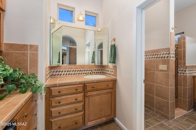 full bath with tasteful backsplash, walk in shower, and vanity