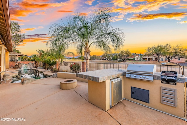 view of patio with area for grilling and an outdoor fire pit