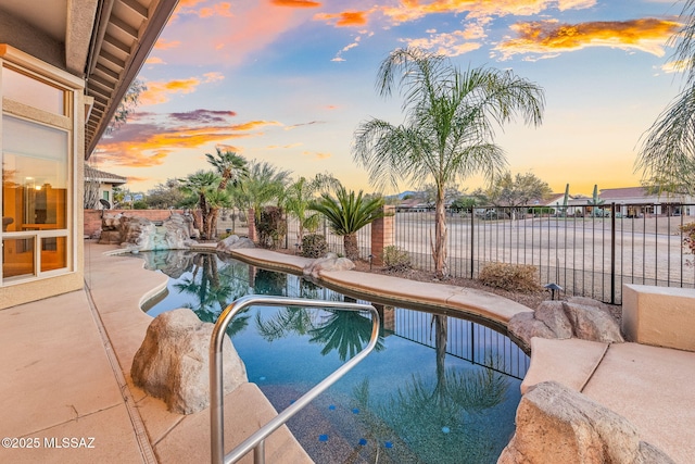 pool at dusk with a fenced in pool, a patio, and a fenced backyard