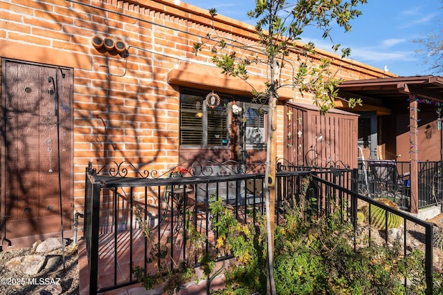 doorway to property with fence and brick siding