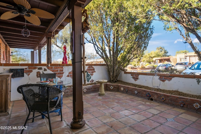 view of patio featuring ceiling fan and fence