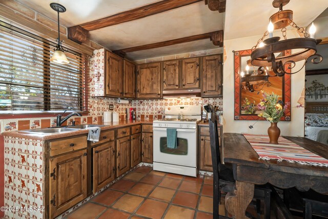 445 S Paseo Quinta Unit C, Green Valley, AZ 85614 - kitchen featuring white gas range, plenty of natural light, beam ceiling, brown cabinets, and tasteful backsplash