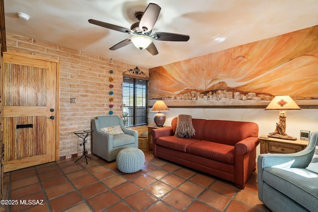 tiled living room with ceiling fan and brick wall