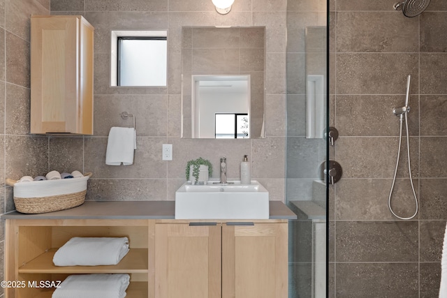 bathroom with backsplash, vanity, and a tile shower