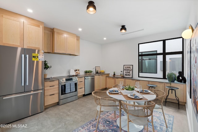 kitchen with appliances with stainless steel finishes, sink, and light brown cabinets