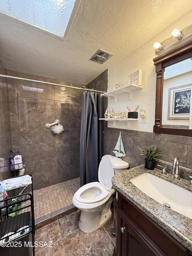 bathroom featuring vanity, toilet, curtained shower, and a textured ceiling