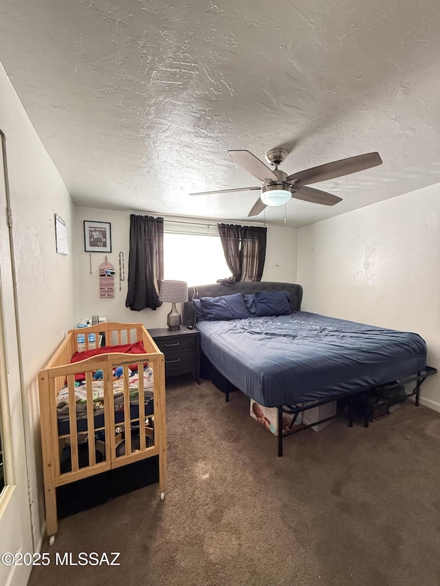 carpeted bedroom featuring ceiling fan and a textured ceiling