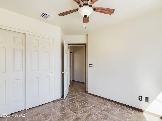 unfurnished bedroom featuring ceiling fan and a closet