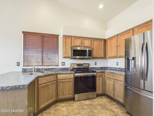 kitchen with vaulted ceiling, appliances with stainless steel finishes, and sink