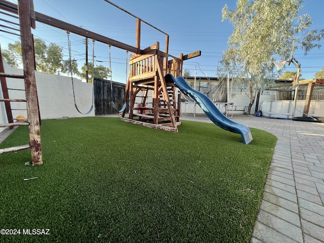 view of playground with a patio and a yard