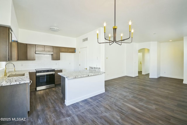 kitchen with electric stove, sink, decorative light fixtures, and light stone countertops