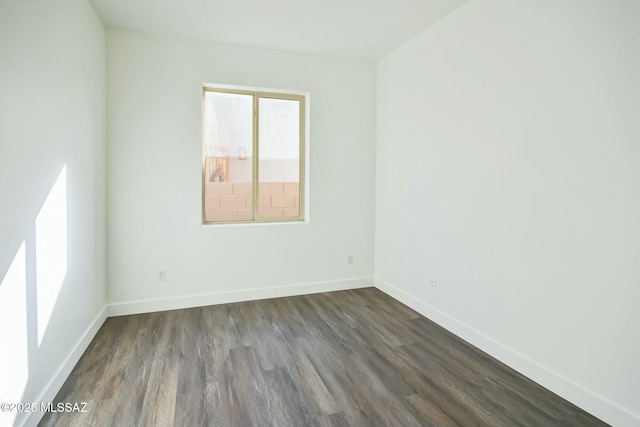 empty room with dark hardwood / wood-style flooring