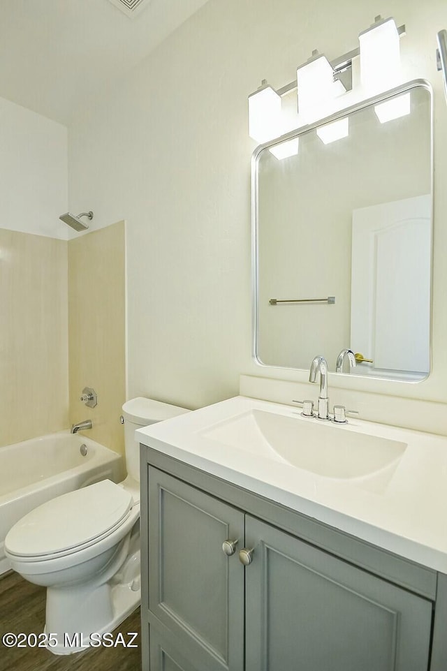 full bathroom featuring vanity, hardwood / wood-style flooring, toilet, and washtub / shower combination