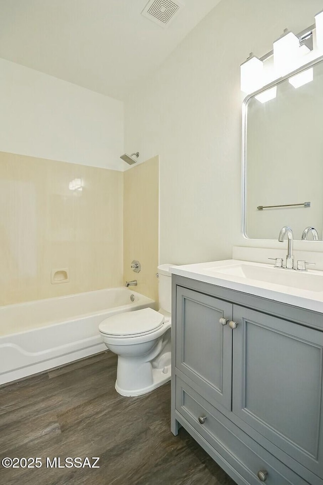 full bathroom featuring wood-type flooring, toilet, shower / bathing tub combination, and vanity