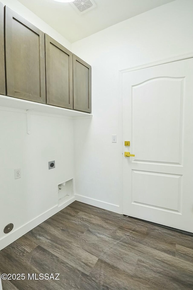 laundry room with cabinets, electric dryer hookup, and dark wood-type flooring