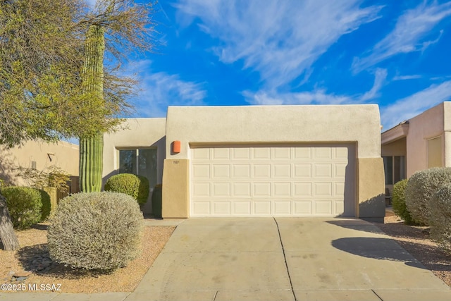 pueblo revival-style home with a garage