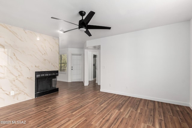 unfurnished living room featuring dark hardwood / wood-style floors, a premium fireplace, and ceiling fan