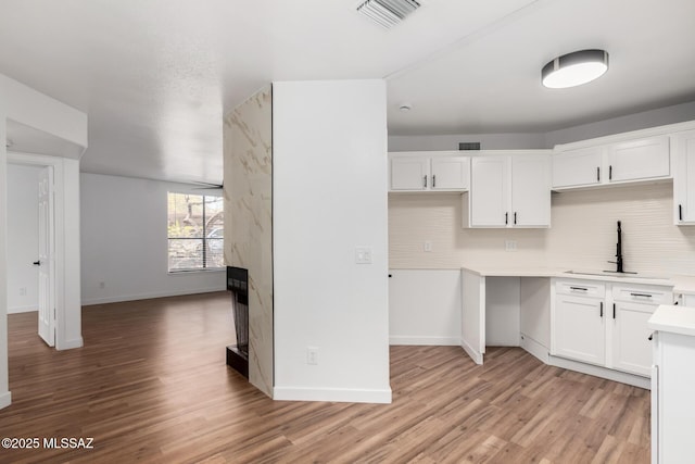 kitchen featuring sink, white cabinets, and light wood-type flooring